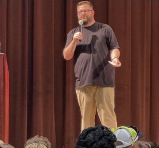 Will Craig delivering an authentic leadership keynote on stage with a microphone